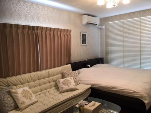 a living room with a couch and a bed at Alphabed Takamatsu Furujinmachi - Vacation STAY 11906 in Takamatsu