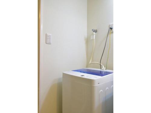 a bathroom with a toilet with a blue top at Alphabed Takamatsu Furujinmachi - Vacation STAY 11905 in Takamatsu