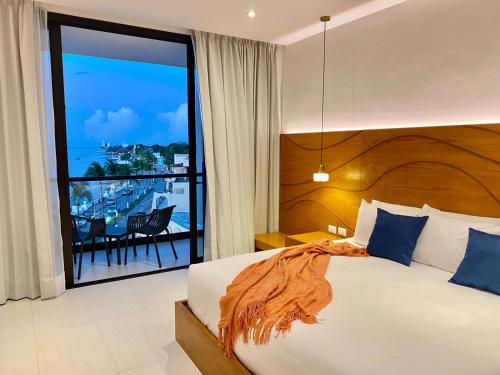 a bedroom with a bed and a view of the ocean at Hotel Puerto Libre in Cozumel