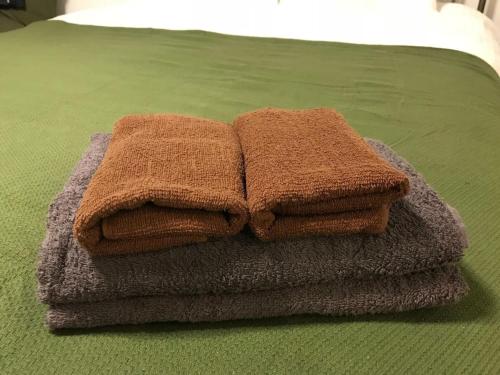 einen Stapel Handtücher auf dem Bett in der Unterkunft AOCA Kaminoge - Vacation STAY 11986 in Tokio