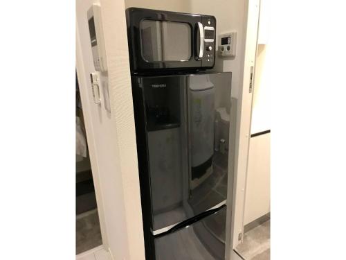 einen kleinen TV über einem Kühlschrank in der Unterkunft AOCA Kaminoge - Vacation STAY 11986 in Tokio