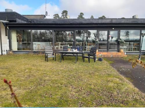 a house with a table and chairs in the yard at BnB Just To Be in Laholm