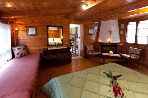 Una habitación con una cama y una chimenea en una cabaña en Pension Eleni, en Nauplia
