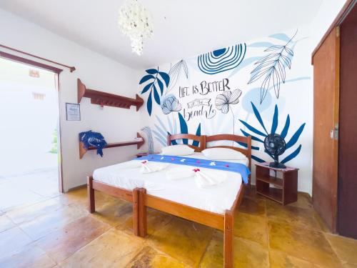 a bedroom with a bed and a wall with a mural at Cumbuco Kite in Paradise e Hospedaria in Cumbuco