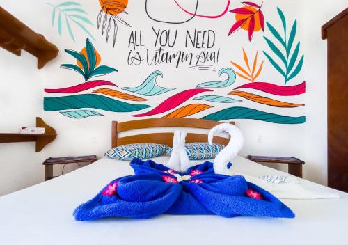 a bedroom with a blue towel on a bed at Cumbuco Kite in Paradise e Hospedaria in Cumbuco