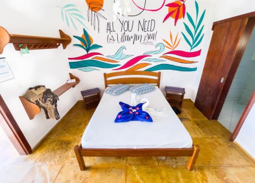a bed in a room with a mural on the wall at Cumbuco Kite in Paradise e Hospedaria in Cumbuco
