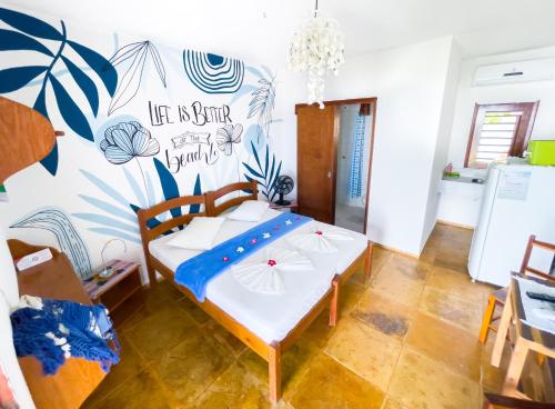a bedroom with a bed in a room with a mural at Cumbuco Kite in Paradise e Hospedaria in Cumbuco