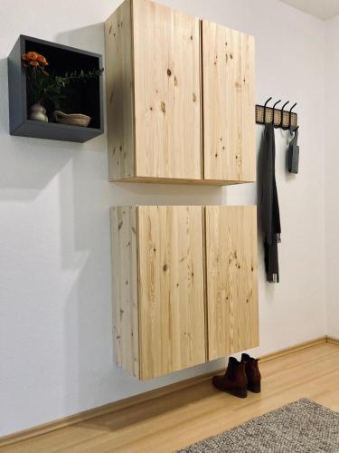 a wooden cabinet hanging on a wall with shoes at Schickes, Stilvolles und Helles Apartment in Münster in Münster