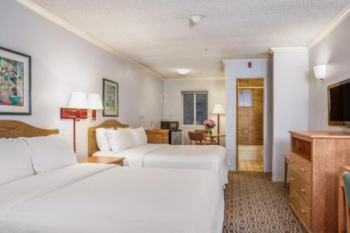 a hotel room with two beds and a television at Hotel Buena Vista - San Luis Obispo in San Luis Obispo