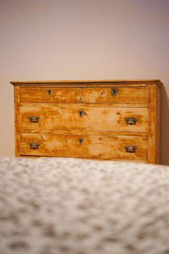 a wooden dresser sitting next to a wall at Lärchenwirt Dolomites in San Nicolò di Comelico