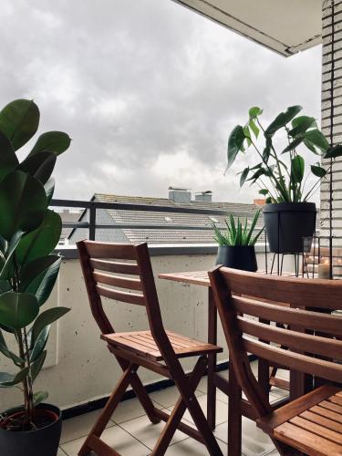 a balcony with two chairs and a table and potted plants at Schickes, Stilvolles und Helles Apartment in Münster in Münster