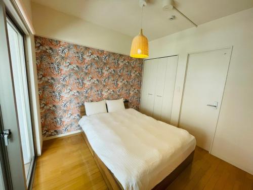 - une chambre avec un lit et un papier peint floral dans l'établissement Cube Haruyoshi Patio - Vacation STAY 92593v, à Fukuoka