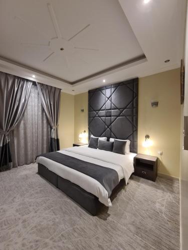 ein großes Schlafzimmer mit einem großen Bett mit einem schwarzen Kopfteil in der Unterkunft Rose Neri Lavender روز نيري الخزامى in Khobar