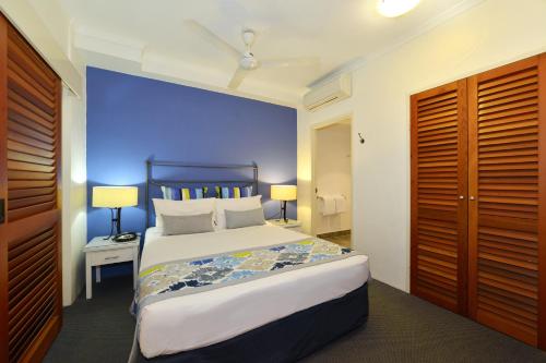 a hotel room with a bed and a dresser at Reef Club Resort in Port Douglas