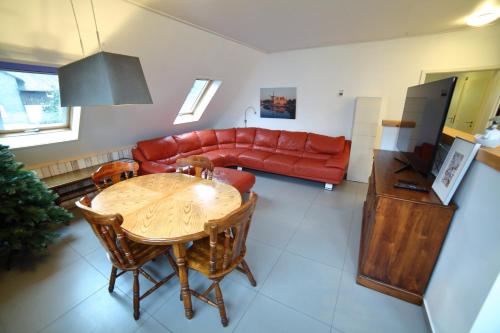 a living room with a table and a red couch at Landhaus Silbach in Winterberg