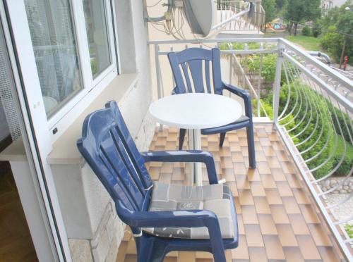 2 blaue Stühle und ein Tisch auf dem Balkon in der Unterkunft Apartments Ivan in Crikvenica