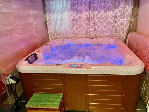 bañera de hidromasaje en una habitación rosa con un color púrpura en SUITE spa accès autonome, en Beaucaire