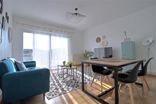 un salon avec une table et un canapé bleu dans l'établissement ADELITAS House, à Agen