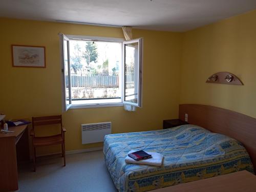 une chambre avec un lit, une fenêtre et un bureau dans l'établissement Studio proche des thermes en rez-de-chaussée avec place de parking, à Bagnères-de-Bigorre