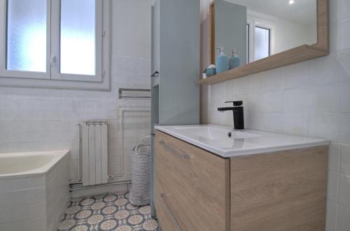 a white bathroom with a sink and a mirror at ADELITAS House in Agen