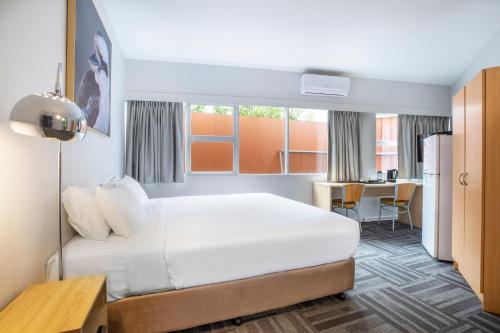 a hotel room with a bed and a kitchen at Meadow Inn Hotel-Motel in Melbourne