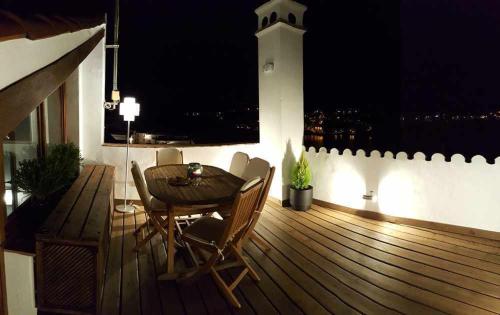 a wooden deck with a table and chairs and a lighthouse at Casa rural La Rabá Terraza con increíbles vistas in Sanlúcar de Guadiana