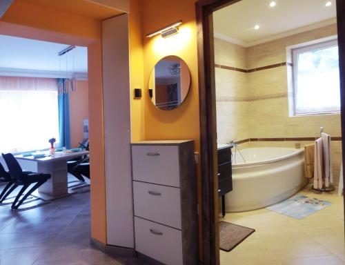 ein Badezimmer mit einer Badewanne und einem Waschbecken in der Unterkunft Pilis Apartman in Piliscsaba
