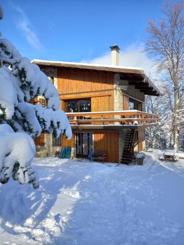 une cabane en rondins dans la neige avec des arbres enneigés dans l'établissement Chalet d'argençon, à Mont Serein