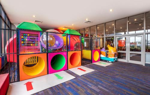 a childrens play area in a building with a playground at Meadow Inn Hotel-Motel in Melbourne