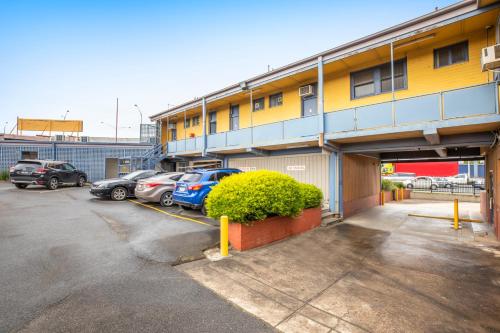 a parking lot with cars parked in front of a building at Meadow Inn Hotel-Motel in Melbourne
