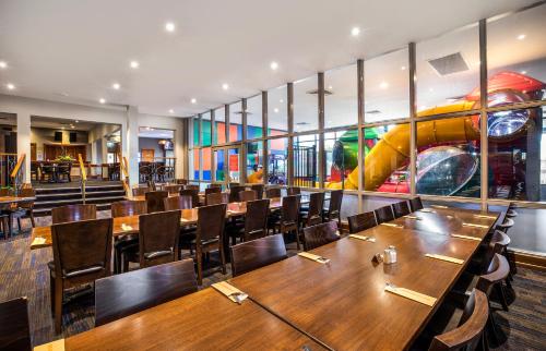 a dining room with wooden tables and chairs at Meadow Inn Hotel-Motel in Melbourne