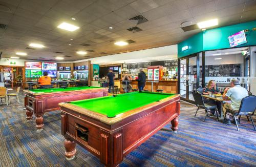 a billiard room with two pool tables in a restaurant at Meadow Inn Hotel-Motel in Melbourne