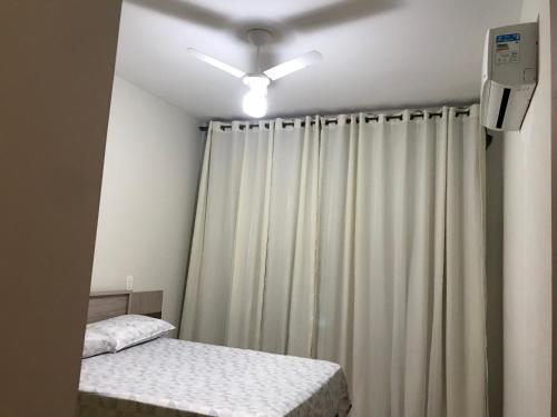 a room with two beds and a white curtain at Apto Alemanha no centro de Ribeirão Preto SP in Ribeirão Preto