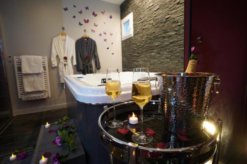 a bathroom with two glasses of wine and a tub at Spa privé et piscine chauffée à 8 km de Toulouse in Montrabé
