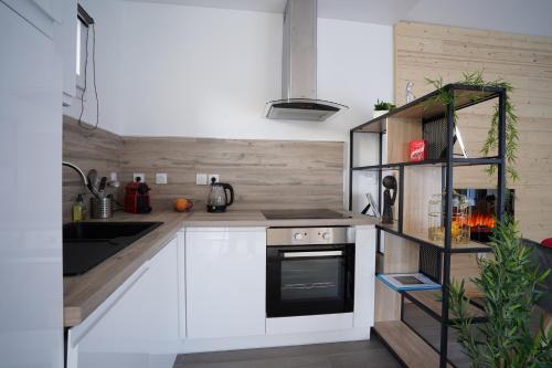 a kitchen with white cabinets and a stove at Spa privé et piscine chauffée à 8 km de Toulouse in Montrabé