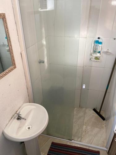 y baño con ducha y lavamanos. en Verde Hostel Ilhabela, en Ilhabela