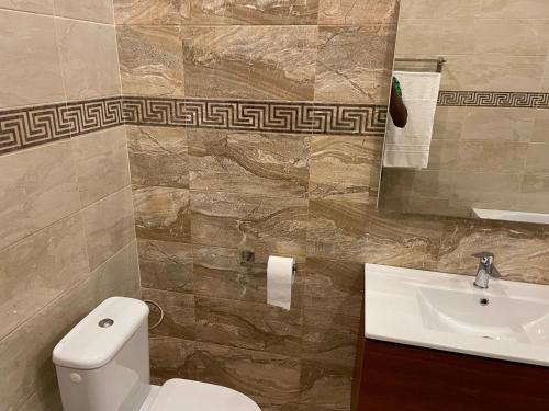 a bathroom with a toilet and a sink at HOTEL LES ARCADES in Abomey-Calavi