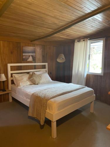 聖特雷莎海灘的住宿－Beach Villa S，卧室配有白色床和木制天花板