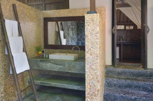 a bathroom with a sink and a mirror at Desa Dunia Beda Resort in Gili Trawangan
