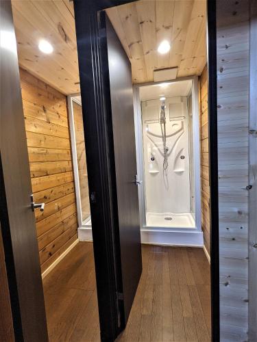 a hallway with a door leading into a room with wooden walls at The Jungle House - Hakuba in Hakuba
