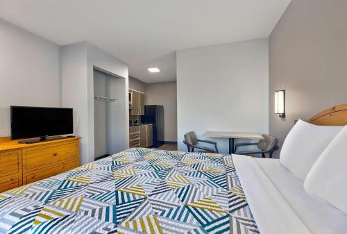 a hotel room with a bed and a flat screen tv at Studio 6-North Richland Hills, TX - Fort Worth in North Richland Hills