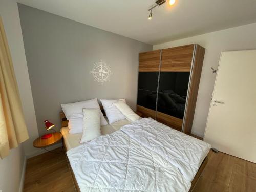 - une chambre avec un lit doté de draps et d'oreillers blancs dans l'établissement Strandpark Großenbrode WR-12, à Großenbrode