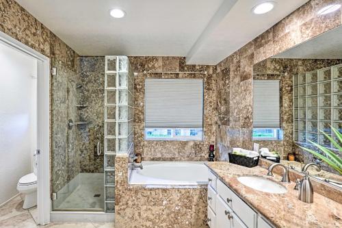 a bathroom with a tub and a sink and a toilet at Pet-Friendly La Quinta Gem with Pool and Yard Games in La Quinta