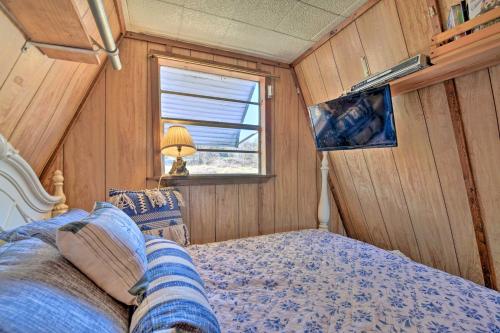 a bedroom with a bed and a window at Steps to Lake! Charming Cabin Pool Access and Decks in Granbury