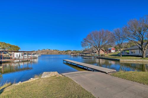 a river with a dock on the side of it at Steps to Lake! Charming Cabin Pool Access and Decks in Granbury
