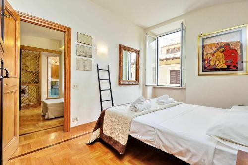 una camera da letto con un grande letto bianco e finestre di Borgo Pio a Roma