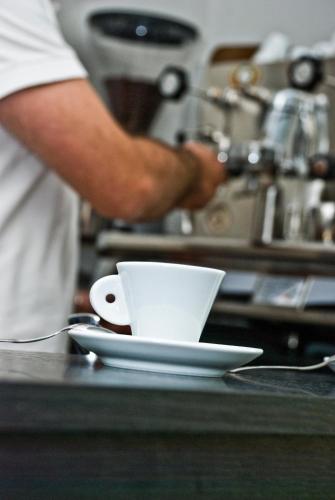 a white cup sitting on a counter next to aucer at Hotel 4 Strade in Ortona
