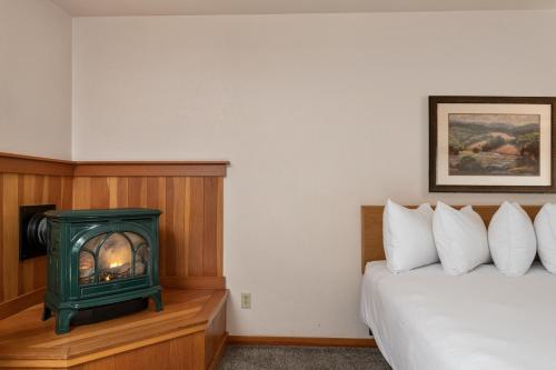 a bedroom with a bed and a green stove in a room at Harbor Lite Lodge in Fort Bragg