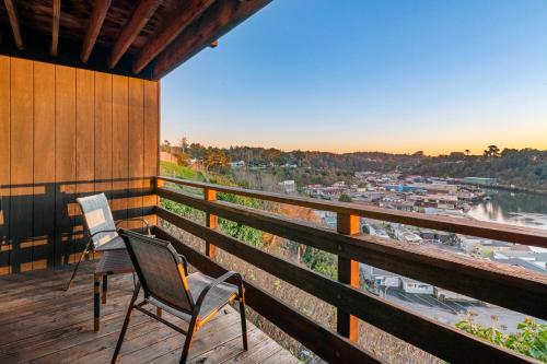 two chairs on a porch with a view of a river at Harbor Lite Lodge in Fort Bragg