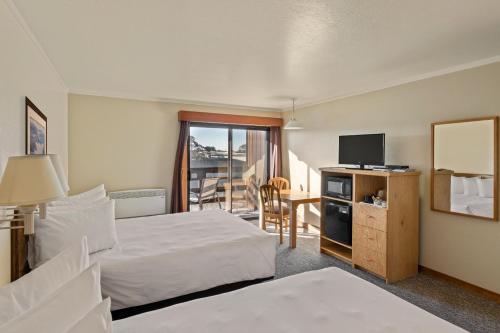 a hotel room with two beds and a television at Harbor Lite Lodge in Fort Bragg